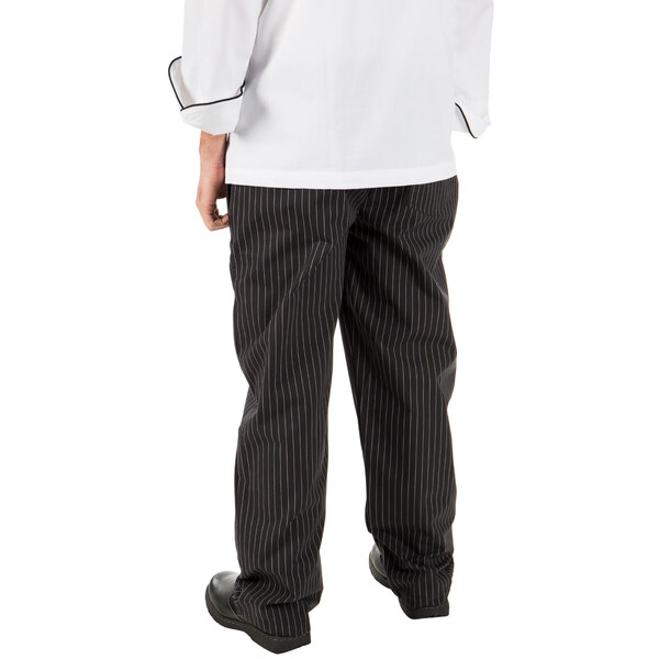 A person wearing Mercer Culinary black pinstripe cook pants.
