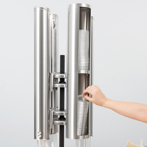 A woman's hand picking up a Vollrath stainless steel lid holder.