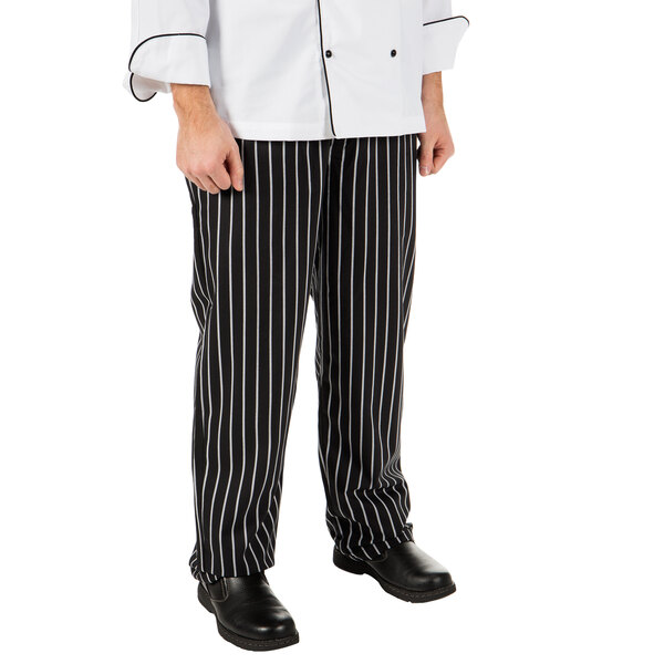 A person wearing Mercer Culinary black and white striped chef pants.