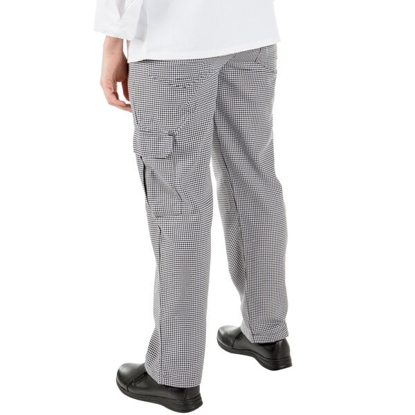A person wearing Mercer Culinary Women's Houndstooth Cargo Pants with their hands in their pockets.