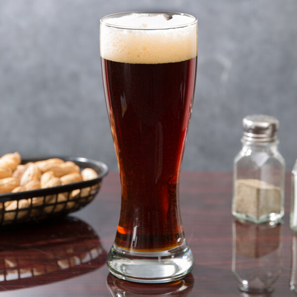 An Anchor Hocking Pilsner glass of beer on a table.