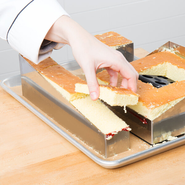 a hand holding a piece of cake