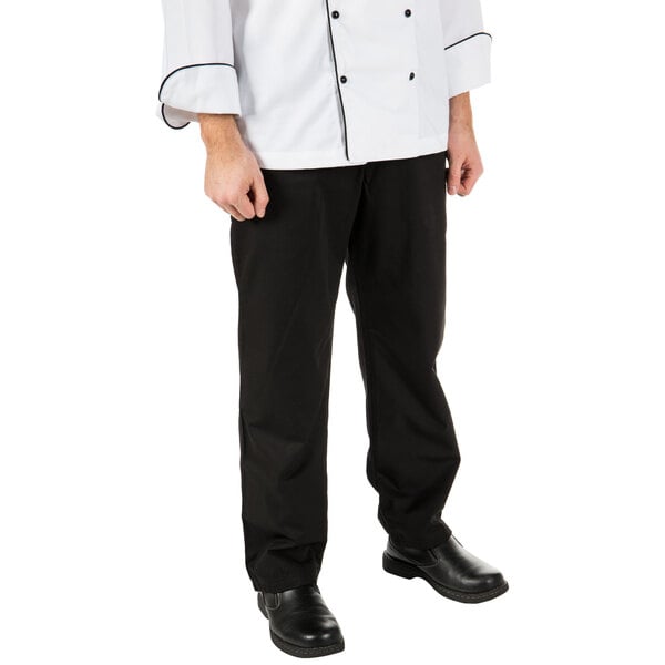 A man wearing Mercer Culinary black chef trousers.