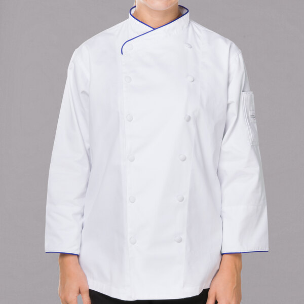 A woman wearing a Mercer Culinary white chef jacket with royal blue piping.