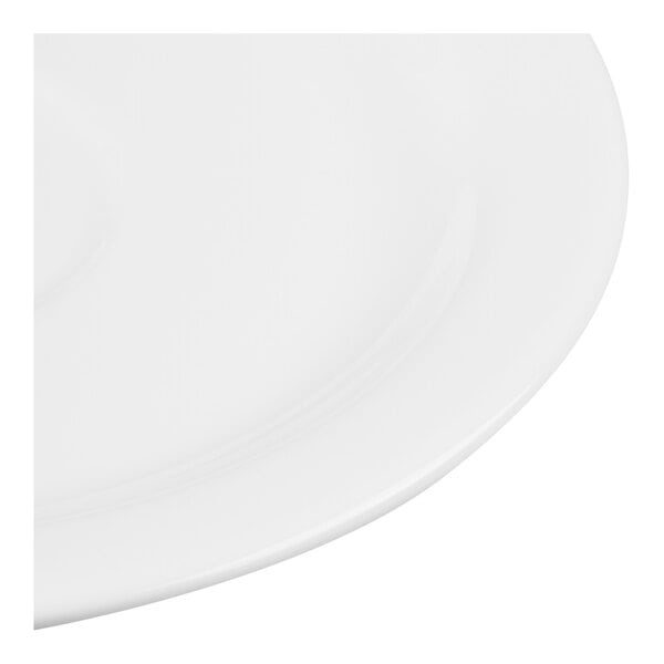 A close-up view of a smooth, white, round ceramic or porcelain surface, likely part of a plate or saucer.