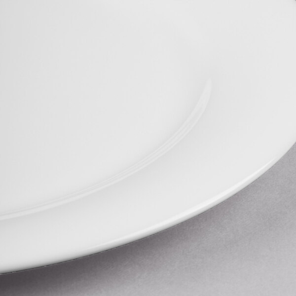 A close-up of a white Reserve by Libbey bone china round plate with a white rim.