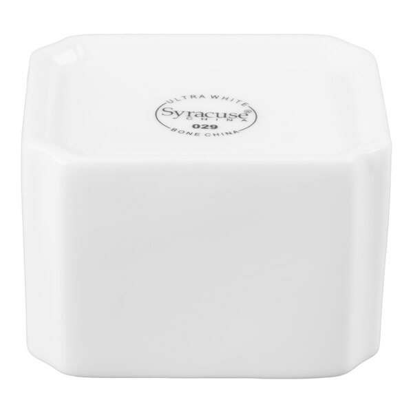 A white, square-shaped ceramic container with slightly rounded edges and a logo on the top surface.