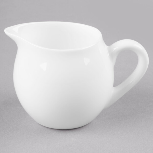 A white Reserve by Libbey bone china creamer with a handle.
