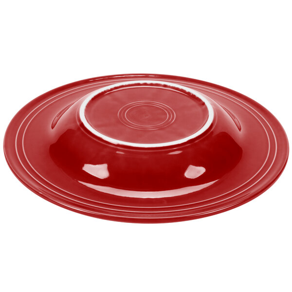 A stack of red Fiesta pasta bowls with a white rim.