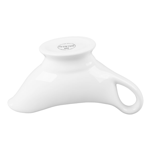 A white, uniquely shaped ceramic vessel with a handle, likely used for serving sauces.
