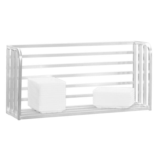 A Channel slotted aluminum boat rack on a white wall with white rectangular objects on it.