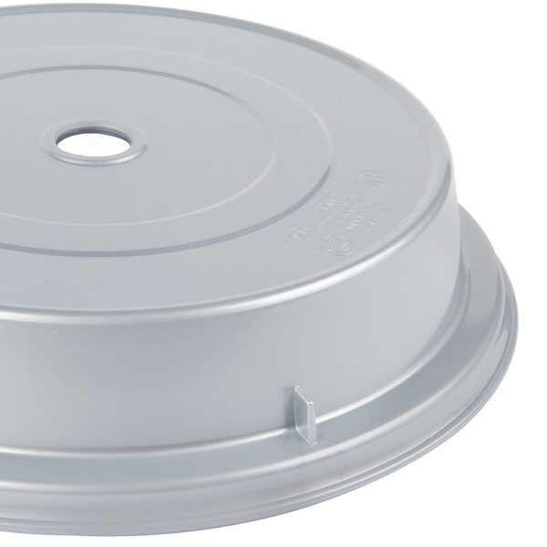 A white plastic Cambro plate cover with a silver metallic lid and a hole in it.