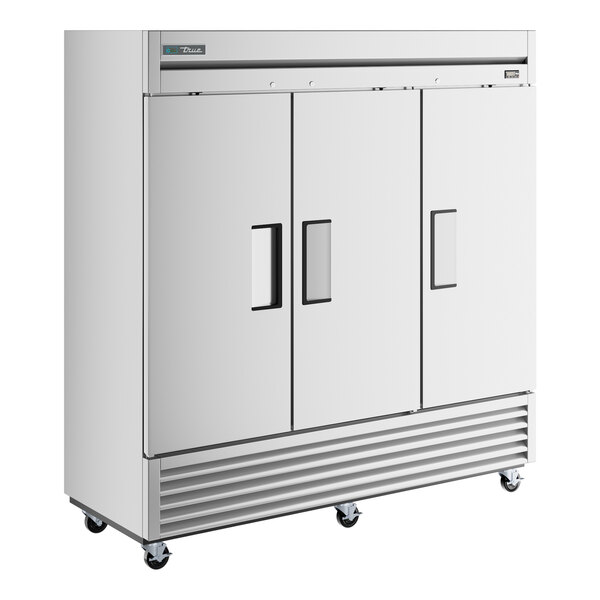 A stainless steel True reach-in freezer with three solid doors.