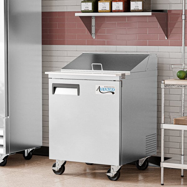 An Avantco stainless steel refrigerated sandwich prep table on a kitchen counter.