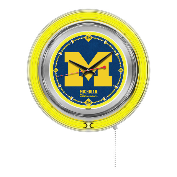 A white wall clock with a yellow and blue University of Michigan logo in neon.