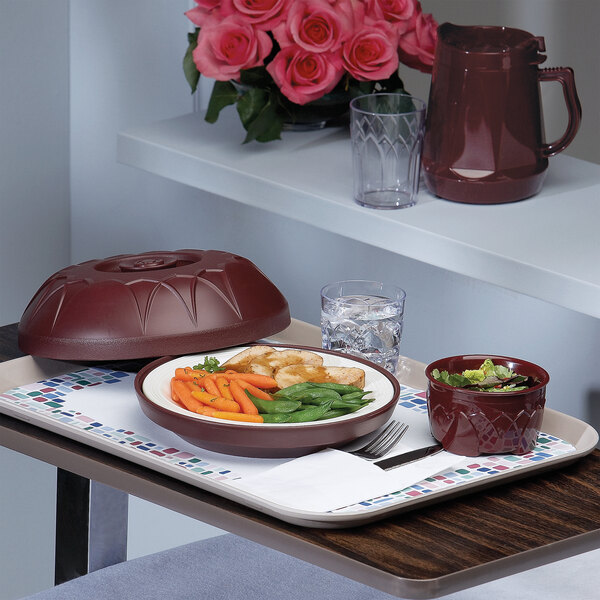 A tray with a bowl of cranberry colored food and a plate of vegetables on it.