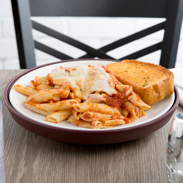 A plate of pasta with bread on an insulated Dinex meal delivery base.