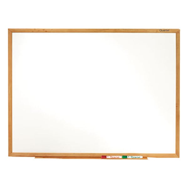 A Quartet melamine whiteboard with an oak frame.