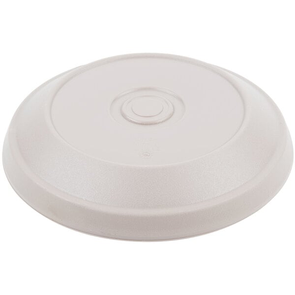 A white plastic Dinex insulated meal delivery disc with a clear circle on top.