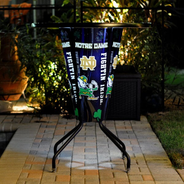 A metal bar height pub table with a University of Notre Dame logo on it.