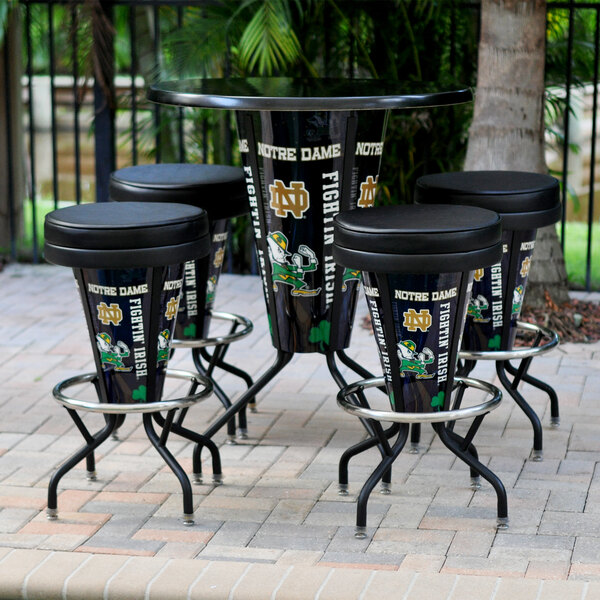 A University of Notre Dame bar height pub table with a green and white logo on it.