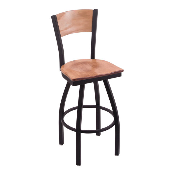 A black steel bar stool with maple wood back and seat engraved with the United States Navy logo.