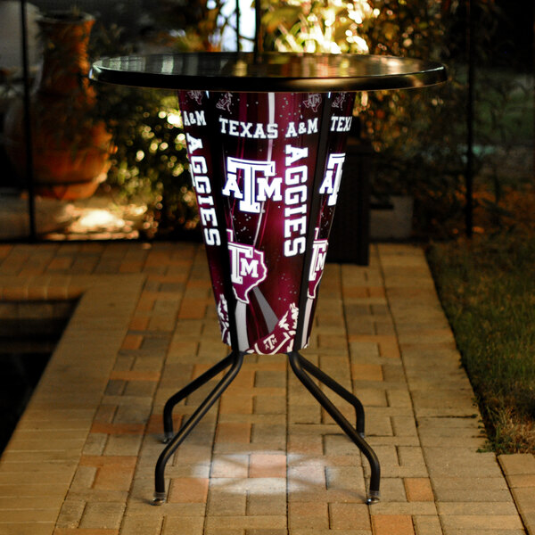 A Texas A&M logo on a lighted round bar height table.
