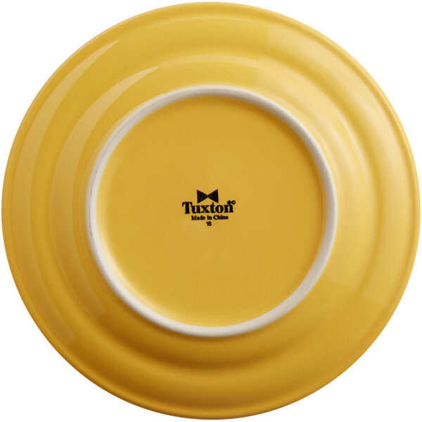A yellow Tuxton Concentrix china plate with a white rim.
