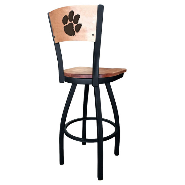 A black steel bar height swivel chair with maple wood back and seat engraved with a Clemson University paw print.