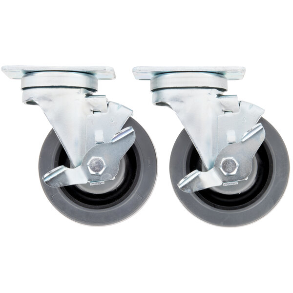 A close-up of a pair of Garland and US Range metal casters with black and grey wheels.