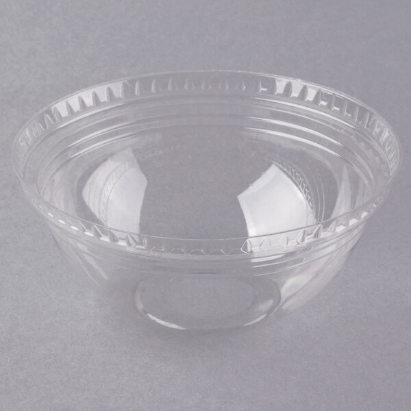 A clear plastic container with a curved lid on a grey surface.