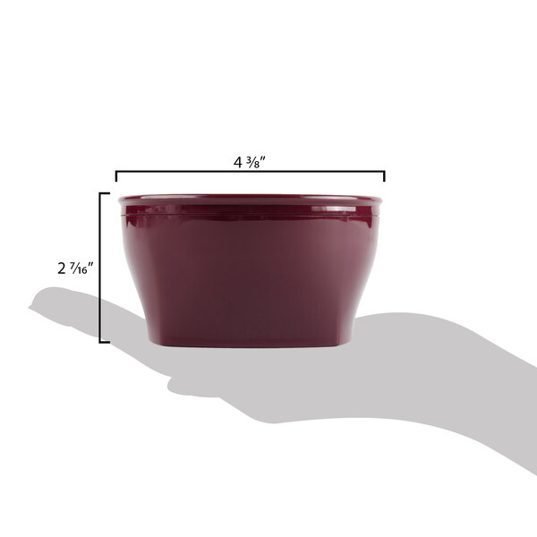 A person holding a red Cambro insulated bowl on a table.