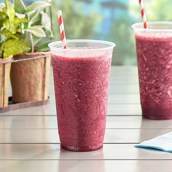 Two Fabri-Kal Nexclear plastic cups with a red smoothie and straws.