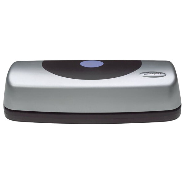 A grey and black Swingline 3 hole punch on a counter.