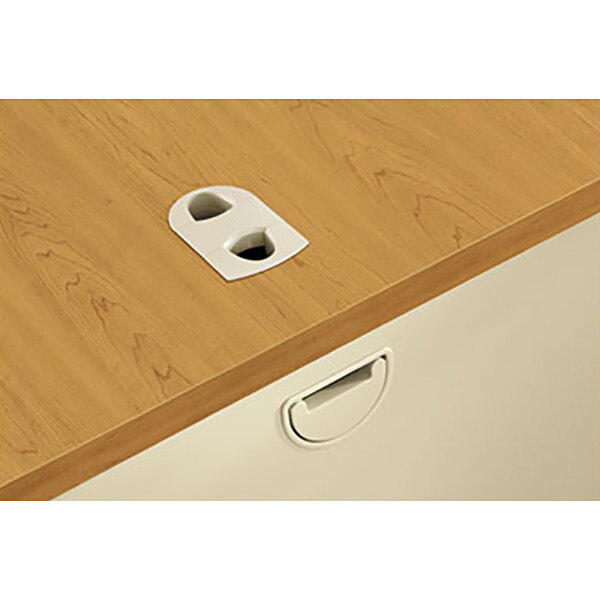 A white metal HON double pedestal desk with white drawer pull handles.