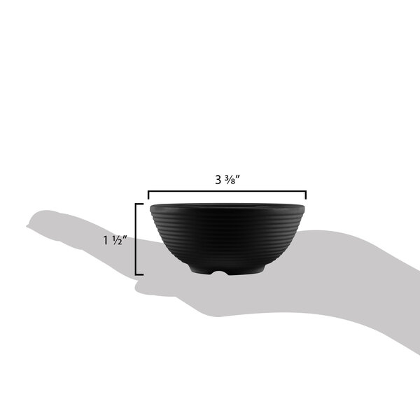 A hand holding a Tablecraft black melamine ramekin with ribbed sides.