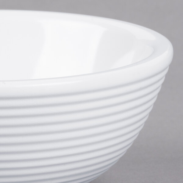 A close-up of a white Tablecraft melamine ramekin with a ribbed rim.