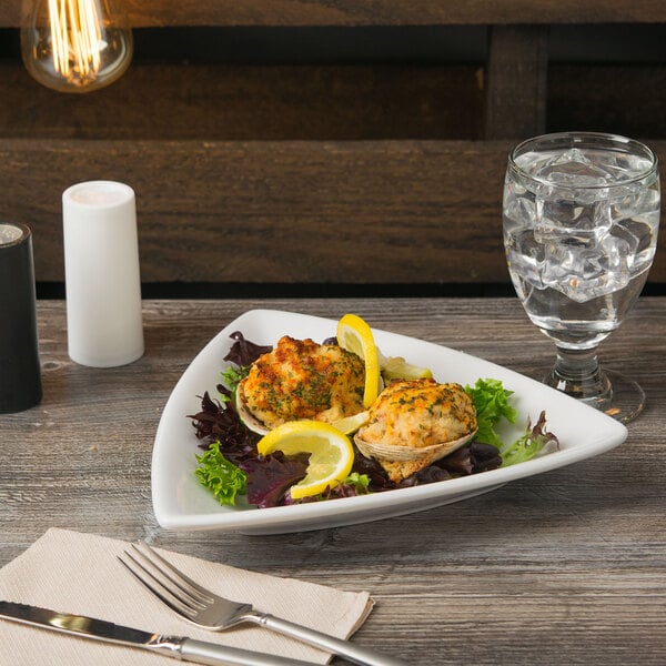 A Libbey Porcelain coupe plate with food on a wood table.