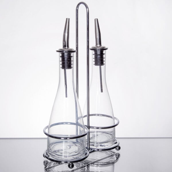 Two Tablecraft glass oil and vinegar cruets with metal holders.
