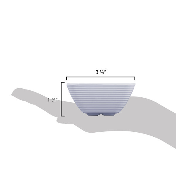 A hand holding a small white Tablecraft ramekin.
