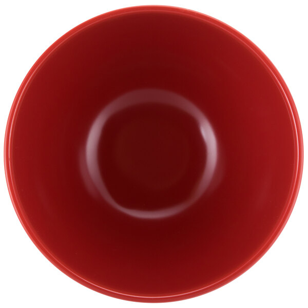 A red melamine bowl with a white interior.