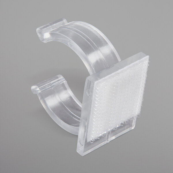 A close-up of a clear plastic Snap Drape table skirt clip.