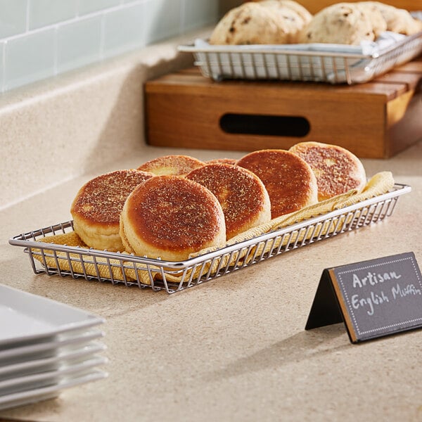 A basket of biscuits on a counter in a bakery display.