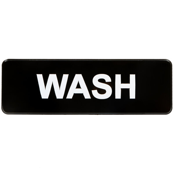 A black sign with white letters that says "Wash"