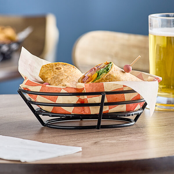 A black Clipper Mill iron basket with food on a wooden table.