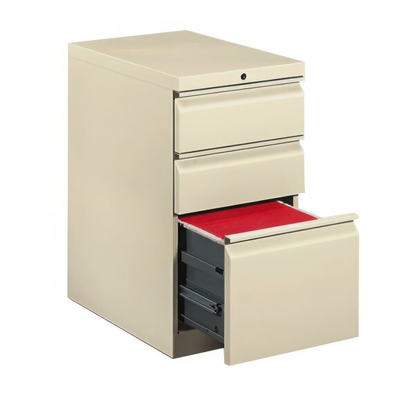 A white filing cabinet with red folders in the drawers.