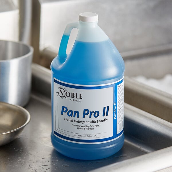 A blue bottle of Noble Chemical Pan Pro II liquid detergent with a white label on a white surface with a black border.