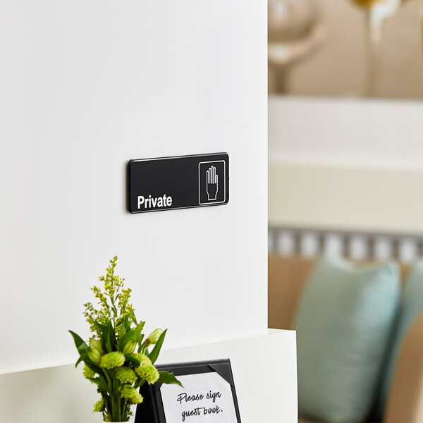 A black and white wall sign that says "Private"