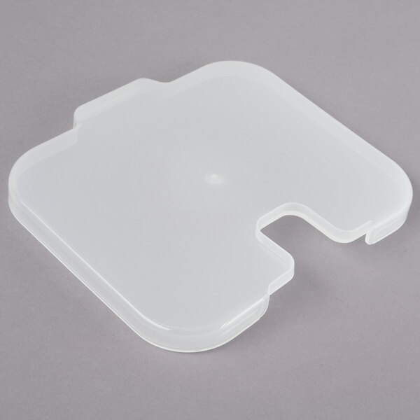 A white plastic container lid with a piece of plastic inside.