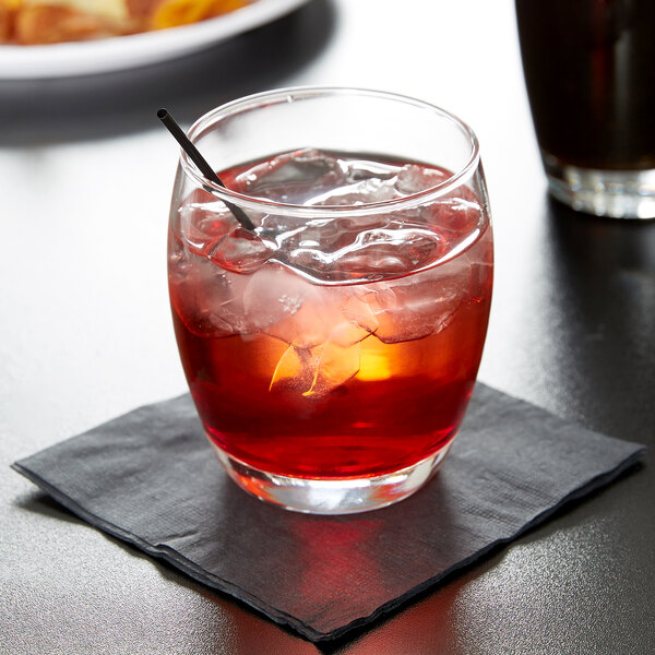 A glass of dark liquid with ice and a straw in an Anchor Hocking Reality Old Fashioned Glass.